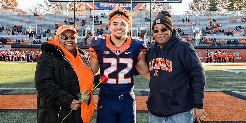 At 2017 Senior Day ceremonies, Foster posed with proud grandparents Diane and James Foster.